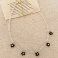 Collar de cristal blanco con cinco colgantes de flores negras y detalles dorados - Collar de flores de cristal negro