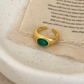 Anello aperto vintage dorato con pietra occhio di gatto ovale su sfondo di tessuto beige - Calcedonio Verde Dorato