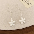 Makro-Detail eleganter weißer Emaille-Ohrringe mit fünfblättriger Blüte und Silberkette - Emaille Marmor Weiß