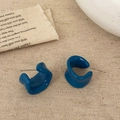Detailopname van donkerblauwe dikke C-vormige oorringen op getextureerd beige linnen doek - Donkerblauw