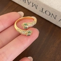 Anello a serpente dorato con zirconi bianchi e pietre verdi indossato sulla mano - Anello Aperto a Forma di Serpente / Oro
