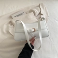 Bolso de hombro blanco en piel sintética con hebilla dorada sobre fondo de traje blanco - Blanco