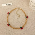Détail du collier de perles ambrées facettées avec petits motifs de cerises - Bracelet de Cheville Jaune