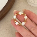 Handgefertigter Retro-Perlenring mit Kristall und Goldperlen am Finger getragen - Muschelperlen Bernstein Kristall Perlenring