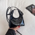 Mini bolso de mano en charol negro con asas metálicas y correa de hombro delgada - Negro