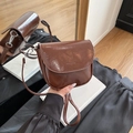 Bolso de montura marrón en charol con diseño semicircular y correa fina ajustable - Marrón