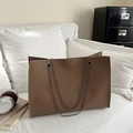 Sac fourre-tout marron foncé en cuir grainé avec bandoulière chaîne sur canapé - Kaki