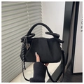 Detail of black faux suede pleated cloud bag with thick braided handle and heart charm - Black + Pendant