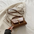 Borsa a tracolla vintage marrone con manico e fibbie dorate su uno sfondo di blazer - Marrone