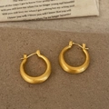 Dettaglio macro di orecchini a U in oro opaco con finitura in metallo spazzolato - Oro Spazzolato