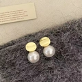 Detail shot of pearl earrings with gold metal discs on a gray textured fabric - Gold Mirror White Pearl