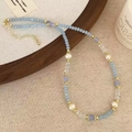 Close-up of pastel blue stone beads and pearls on a natural linen and wood setting - Blue Crystal Freshwater Pearl Style (D-263)