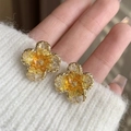 Macro shot of yellow flower earrings with gold plating and faceted crystals - Beige Flower Stud Earrings