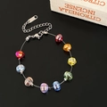 Pulsera de circonitas arcoíris facetadas con cierre plateado sobre fondo negro - Pulsera de cuentas de calabaza de colores