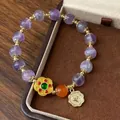 Détail d'un bracelet vintage avec perles en cristal violet et pendentif fleur dorée - Style Médaille d'Or Fleur Améthyste Rétro (D-159)