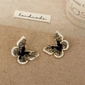 Luxurious gold butterfly stud earrings with black crystals and stones on brown backdrop - Black