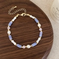 Macro detail of beaded necklace with freshwater pearls, purple stone, and bone charm - Purple Agate Freshwater Pearl Bracelet