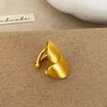 Vista macro de orejera dorada mate con un diseño minimalista y estilo moderno - Ear Cuff de Oro Cepillado