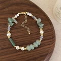Detail of freshwater pearl and green stone beaded necklace on wooden tray with warm lighting - Green Aventurine Freshwater Pearl Bracelet