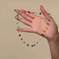 Macro-opname van een kleurrijke gefacetteerde kralenketting met een metalen karabijnslot - Meerkleurige Pompoen Kralen Ketting