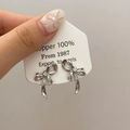 Détail de boucles d'oreilles nœud argentées au style métal liquide sur carte - Boucles d'Oreilles Clous Nœud Style Métal Liquide Argentées (A-808)