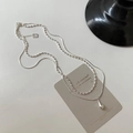 Detail of silver double-layered necklace featuring a polished water drop pendant - Silver