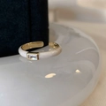 Close-up of golden ring with white enamel finish and inset rectangular zircon stone - White