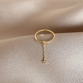 Detail of adjustable gold star ring with dangling zircon charm on silk background - Gold Star Zirconia Chain Adjustable Style
