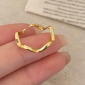 Close-up of a minimalist golden wavy textured open ring with a polished metal finish - Gold Wave Ring