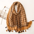 Detail of bohemian geometric print scarf with soft tassels and earthy tones texture - Camel
