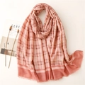 Pink and brick red plaid scarf with gold foil threads and fringed edges on a flat surface - Dusky Pink