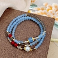 Primer plano detallado de pulsera de varias capas con cuentas celestes y rojas - Estilo Multicapa Étnico Mezcla de Colores (D-133)