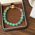 Détail d'un bracelet en perles avec pierres vertes et breloque dorée de fortune - Pierre Verte Rose Pendentif Sac de Fortune (D-211)