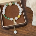 Détail du bracelet perlé avec pierres vertes, pièces d'or et breloque ours en cristal - Pierre Blanche Verte Pendentif Ours (D-201)