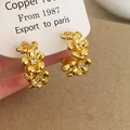 Detail of gold flower earrings with three petals and cubic zirconia stones on card - Gold