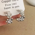 Close-up of double-layer flower hoop earrings made of copper with cubic zirconia accents - Silver