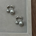 Primer plano de elegantes pendientes de doble perla gris con base de metal plateado en forma U - Plata/Perla Gris