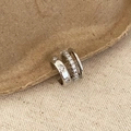 Detailopname van driedelige zilveren ear cuff set met zirkonia op kraftpapier - Zilveren meerlaagse zirkonia oormanchet