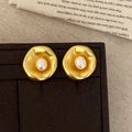 Dettaglio di orecchini di perle in oro opaco con trama martellata su scatola regalo - Oro
