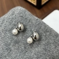 Dettaglio di orecchini a goccia d'argento con perle bianche su sfondo in maglia grigia - Orecchini con Perle ad Alta Lucentezza Argento
