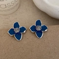 Detail of blue flower stud earrings with enamel petals on minimalist paper background - Blue