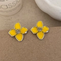 Macro shot of yellow enamel floral earrings with silver beaded center and metallic edges - Yellow