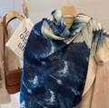 Blue and white gradient scarf with feather patterns styled on a beige coat - Wing Blue