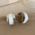 Vista macro de pendientes de aro en C plateados con detalles ondulados de esmalte blanco - Blanco Plateado