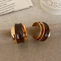 Primer plano de los pendientes vintage en forma de C en oro y esmalte marrón elegante - Dorado Marrón