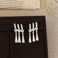 Gros plan de boucles d'oreilles goutte d'eau argent mat sur présentoir de luxe - Style à Franges Argentées / Argenté
