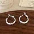 Pendientes de aro retorcidos en plata mate sobre una bandeja de joyería de madera oscura - Pendientes Retorcidos Plata Mate (A-158)