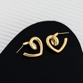 Vue macro de boucles d'oreilles cœur dorées au design épuré et finition polie - Doré