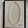 Primo piano di collana di perle bianche da 10mm con chiusura ovale in argento in astuccio - Collana di perle bianche da 10mm