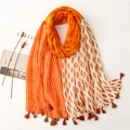 Close-up of bohemian floral geometric cotton scarf with colorful tassel edge detail - Orange